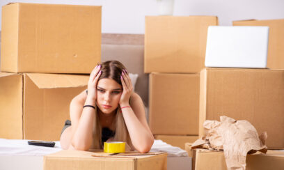 sad home owners stressed about packing and hunching over boxes.